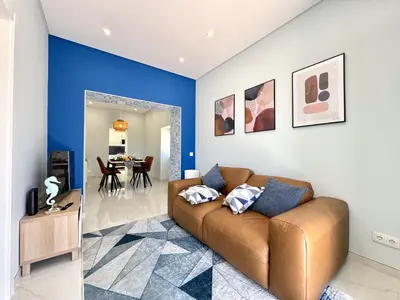 a living room with a brown couch and a blue wall at Almancil Typical House by Homing in Almancil