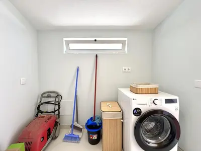 a room with a washing machine and mop at Almancil Typical House by Homing in Almancil