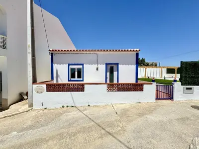 a small white house with a blue door at Almancil Typical House by Homing in Almancil