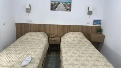 a room with two beds and a wooden desk at Casa Tapada do Bento II- Albufeira in Albufeira
