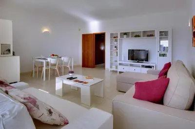 a living room with a white couch and a table at Atlantic Horizon by Seareen in Albufeira