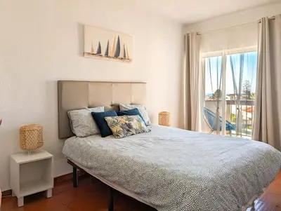 a bedroom with a large bed with a window at Sunset in Albufeira