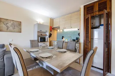 a kitchen and dining room with a table and chairs at Apartamento Perfeito in Albufeira