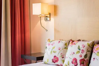 a hotel room with a bed with pillows and a lamp at Vila Sol F5 W Golf and Pool Apartment in Vilamoura