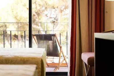 a room with a window with a chair on a balcony at Vila Sol F5 W Golf and Pool Apartment in Vilamoura