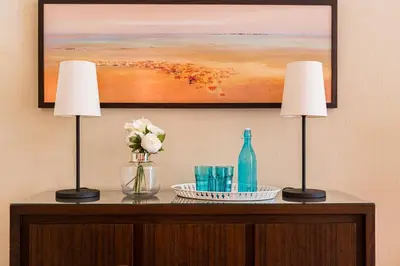 a table with two lamps and a painting on the wall at Vila Sol F5 W Golf and Pool Apartment in Vilamoura
