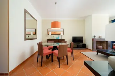 a living room with a table and chairs at Vila Sol F5 W Golf and Pool Apartment in Vilamoura