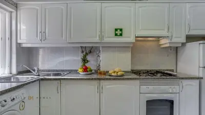 a kitchen with white cabinets and fruits on the counter at Greice Homes - T2 - JV - Vilamoura Centre in Quarteira
