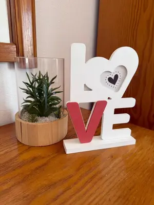 a wooden sign for the word love next to a plant at Costa Mar by Albufeira Rental in Olhos de Água