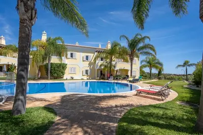 a villa with a swimming pool and palm trees at Casa Vista Brejos in Albufeira