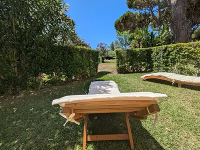 a chair sitting on top of a table in the grass at Solar dos Pinheiros T3 in Vilamoura