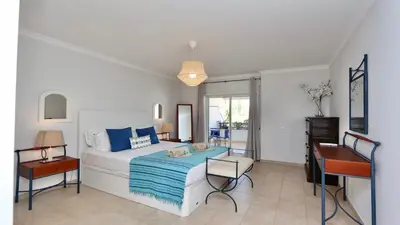 a bedroom with a bed with blue pillows and a desk at Mediterraneo 2ºB - CD 318, Cleverdetails - sleeps 2 adults and 1 child in Vilamoura