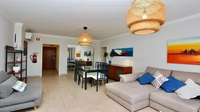 a living room with a couch and a dining room at Mediterraneo 2ºB - CD 318, Cleverdetails - sleeps 2 adults and 1 child in Vilamoura