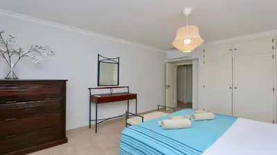 a bedroom with a bed and a dresser and a piano at Mediterraneo 2ºB - CD 318, Cleverdetails - sleeps 2 adults and 1 child in Vilamoura