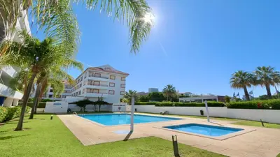 a swimming pool with palm trees and a building at Mediterraneo 2ºB - CD 318, Cleverdetails - sleeps 2 adults and 1 child in Vilamoura