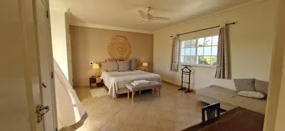 a bedroom with a bed and a couch and a window at Casa Amani in Loulé