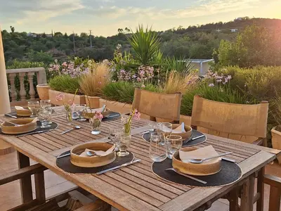 a wooden table with plates and glasses on it at Casa Amani in Loulé