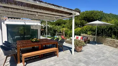 a patio with a wooden table and chairs and an umbrella at Tropicana by Check-in Portugal in Albufeira