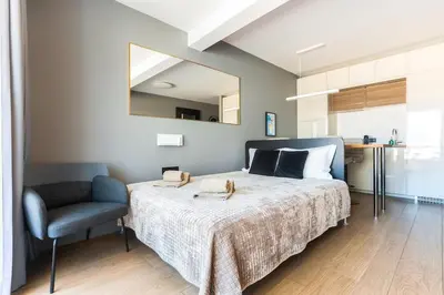 a bedroom with a bed and a chair and a mirror at Gorgeous Flat 3min Walk to Beach in Albufeira