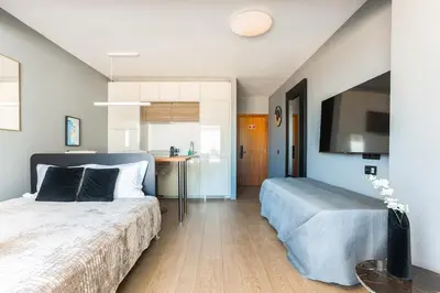 a bedroom with a bed and a table and a tv at Gorgeous Flat 3min Walk to Beach in Albufeira
