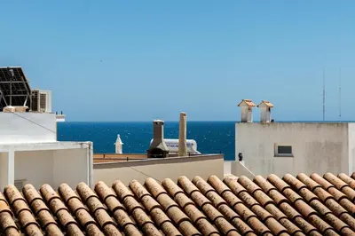 a roof of a building with the ocean in the background at Gorgeous Flat 3min Walk to Beach in Albufeira