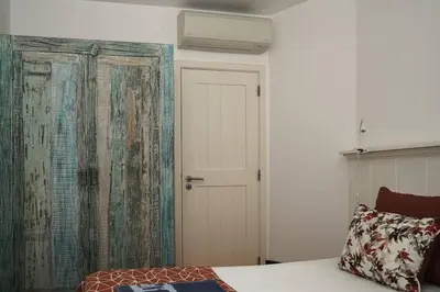 a bedroom with a bed and a door and a wall at Breathtaking BeachFront House in Albufeira