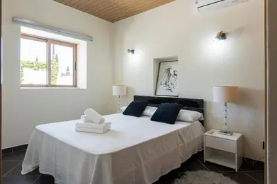 a white bedroom with a bed with two pillows on it at Casa Do Vale - Algarve in Vargem da Mão