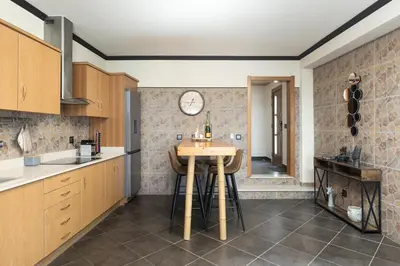 a kitchen with a table and a clock on the wall at Casa Do Vale - Algarve in Vargem da Mão