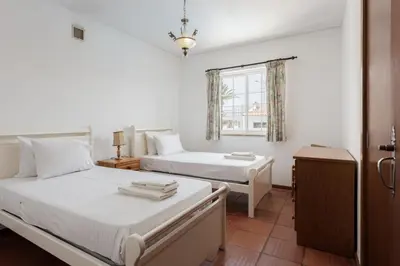 a bedroom with two beds and a window at Vila Coelho - City center with pool by HD in Vale de Pedras