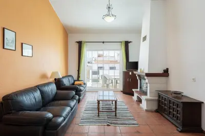 a living room with a leather couch and a table at Vila Coelho - City center with pool by HD in Vale de Pedras