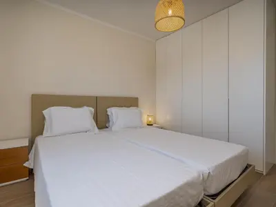 a bedroom with a large bed with white sheets at Duplex T2 com terraço e BBQ em Vilamoura in Quarteira