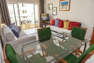 a living room with a glass table and chairs at A02 - Casa Topazio in Quarteira in Quarteira
