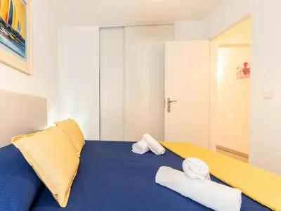 a bedroom with a blue bed with towels on it at Akisol Albufeira Getaway in Olhos de Água