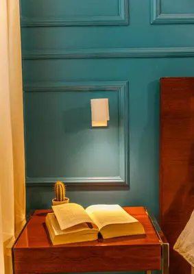 an open book on a wooden table with a lamp at Fly House Faro in Faro