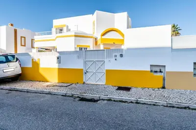 a yellow and white building with a car parked in front at Pet-Friendly with Private Pool Close to the Beach in Galé