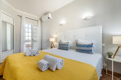 a bedroom with a large bed with towels on it at Pet-Friendly with Private Pool Close to the Beach in Galé