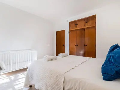 a white bedroom with two beds and a wooden cabinet at Villa Paradis Paraiso com piscina privada em Albufeira in Albufeira