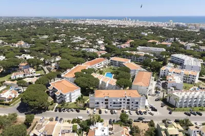 an aerial view of a building with a city in the background at NEW! Vilamoura Garden View in Quarteira