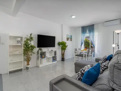 a living room with a couch and a flat screen tv at Algarsol 1bdr apartment near the beach in Quarteira