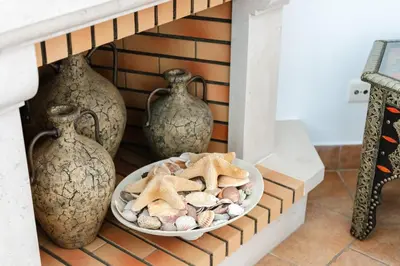 a bowl of shells and vases on a shelf at Charming Villa with Private Pool by LovelyStay in Albufeira