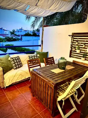 a patio with a table and chairs and a couch at Oura beach & sun in Albufeira