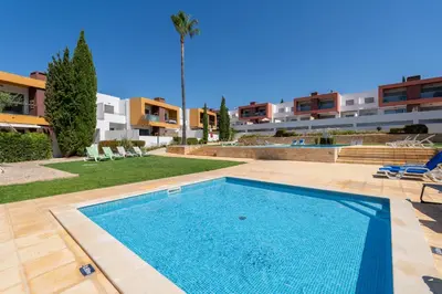a swimming pool in front of a building at Vitismar GroundFloor Apartment with Direct Pool Access in Albufeira in Guia