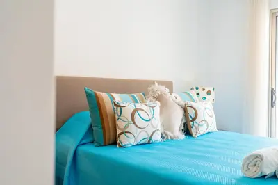 a blue bed with many pillows on it at Vitismar GroundFloor Apartment with Direct Pool Access in Albufeira in Guia