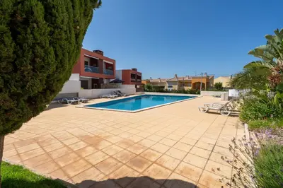 a swimming pool in the middle of a yard with trees at Vitismar GroundFloor Apartment with Direct Pool Access in Albufeira in Guia
