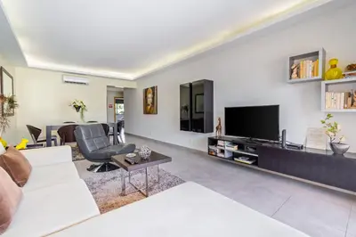 a living room with a white couch and a television at Vitismar GroundFloor Apartment with Direct Pool Access in Albufeira in Guia