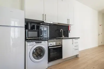 a kitchen with a washing machine and a sink at Downtown 1 Bedroom Apartment E - 150m from the Beach in Albufeira