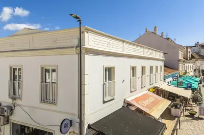 a white building with a sign on the side of it at Downtown 1 Bedroom Apartment E - 150m from the Beach in Albufeira