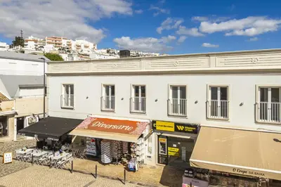 a white building with a sign on the front of it at Downtown Studio Apartment F - 150m from the Beach in Albufeira
