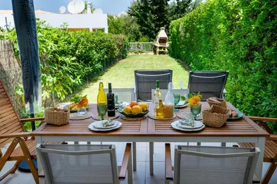 a wooden table with food and drinks on a patio at Sunset Villa No 19 in Galé
