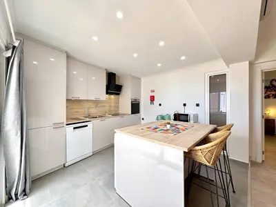 a kitchen with white cabinets and a wooden counter top at Albufeira Amazing View With Pool by Homing in Albufeira